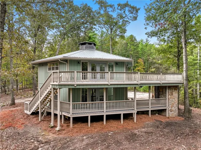 a backyard of a house with large trees and wooden fence