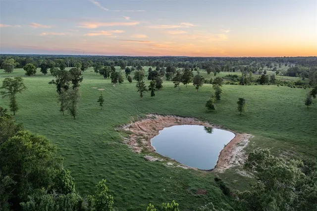 an aerial view of a house with yard and lake view