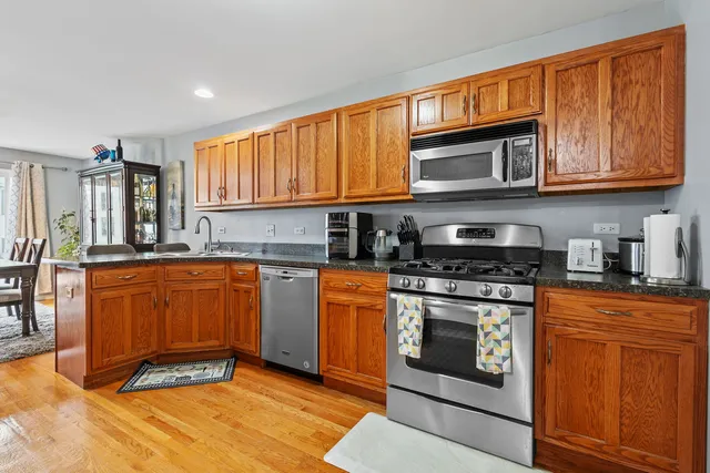 a kitchen with stainless steel appliances granite countertop a stove a sink and a microwave