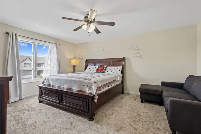 a bedroom with a bed and a flat tv screen on dresser