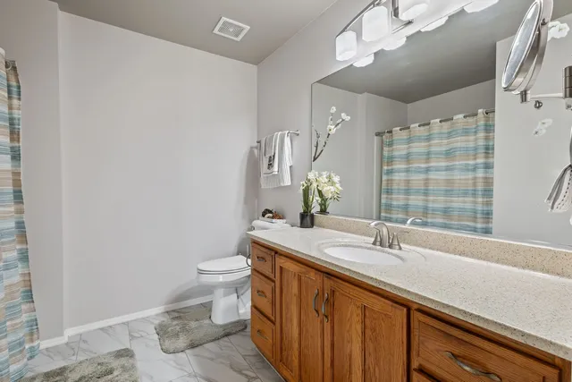 a bedroom with a large bed and a potted plant on table