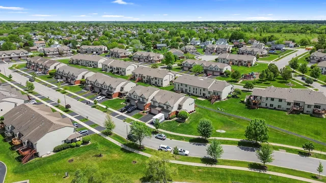 an aerial view of residential houses with outdoor space and street view