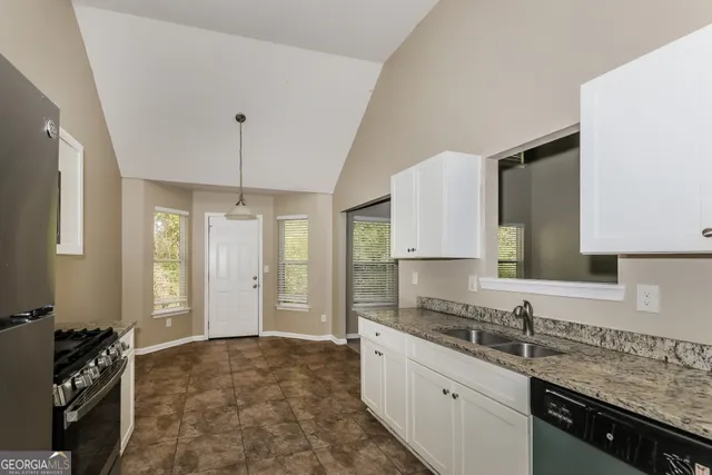 a kitchen with granite countertop a sink and cabinets
