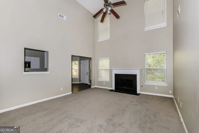 an empty room with windows and fireplace