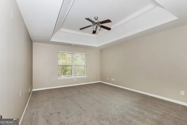an empty room with window and ceiling fan