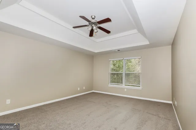 an empty room with window and ceiling fan