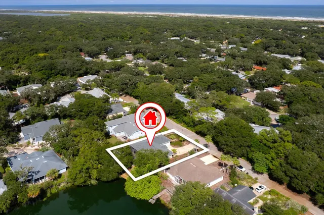 an aerial view of a house with a yard and lake view
