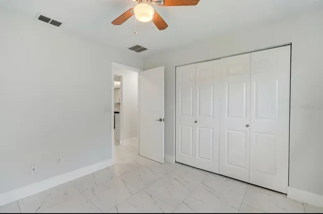 a view of an empty room and chandelier fan