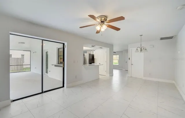 a view of a big room with wooden floor and a kitchen