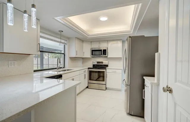 a kitchen with granite countertop a refrigerator stove and sink