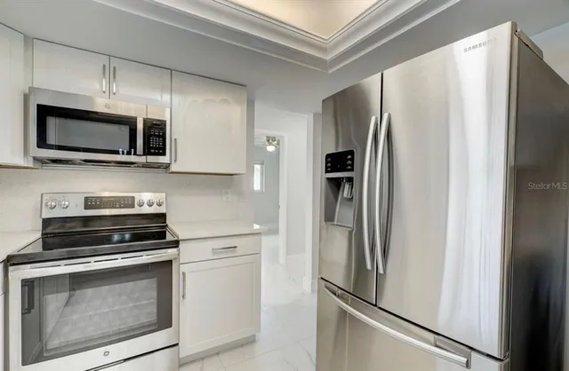 a kitchen with stainless steel appliances a refrigerator stove and microwave