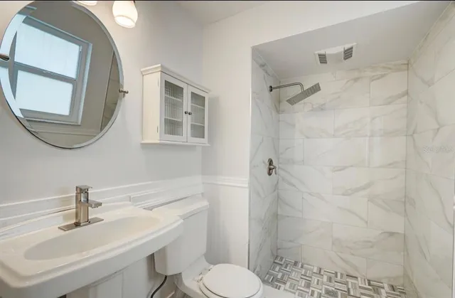 a bathroom with a sink toilet and shower