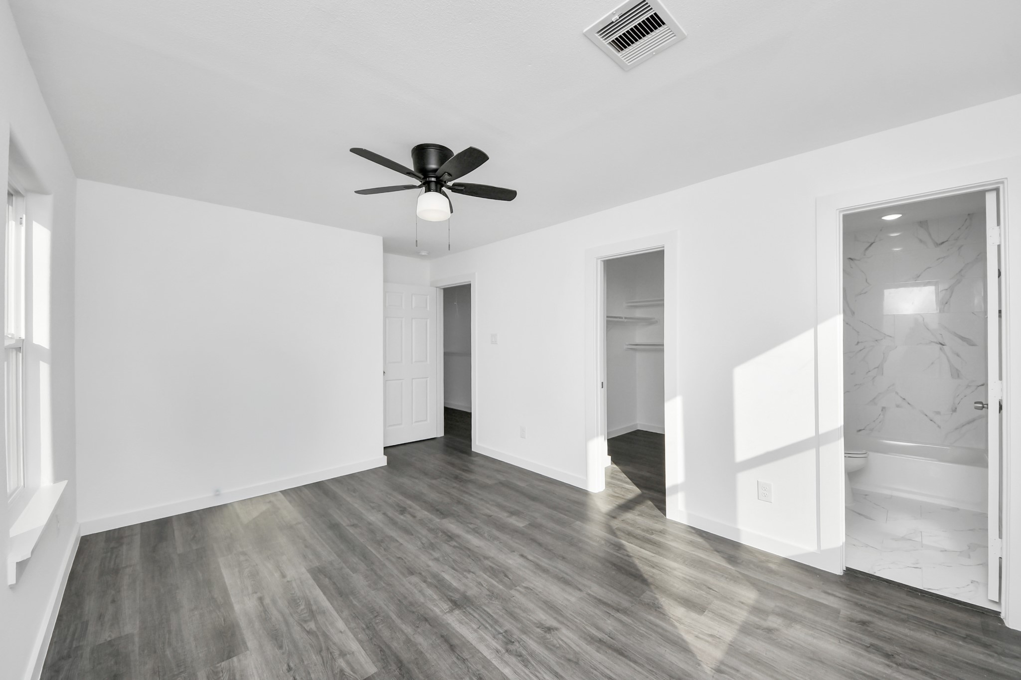 2310 Wavell Street, Unit B Houston, TX 77088 - Photo 29 of 37 an empty room with wooden floor and a ceiling fan