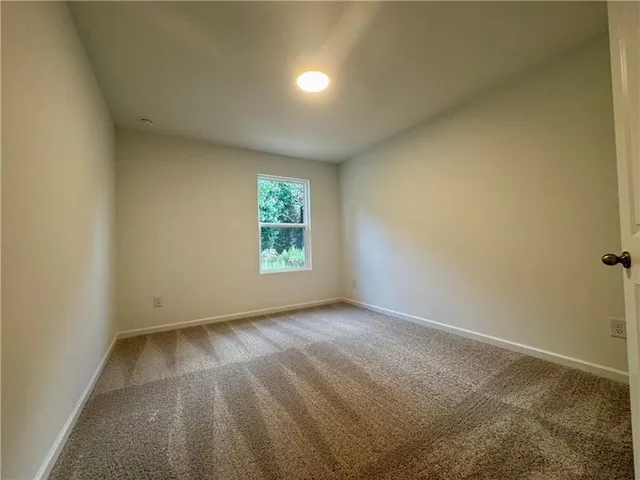 an empty room with white cabinet and mirror