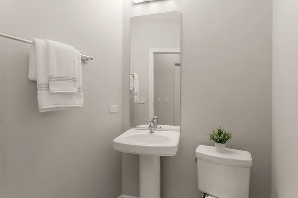 a bathroom with a sink a toilet and a mirror