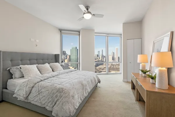 a spacious bedroom with a bed and a lamp