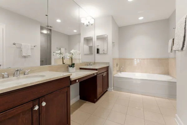 a bathroom with a granite countertop sink a large mirror and bathtub