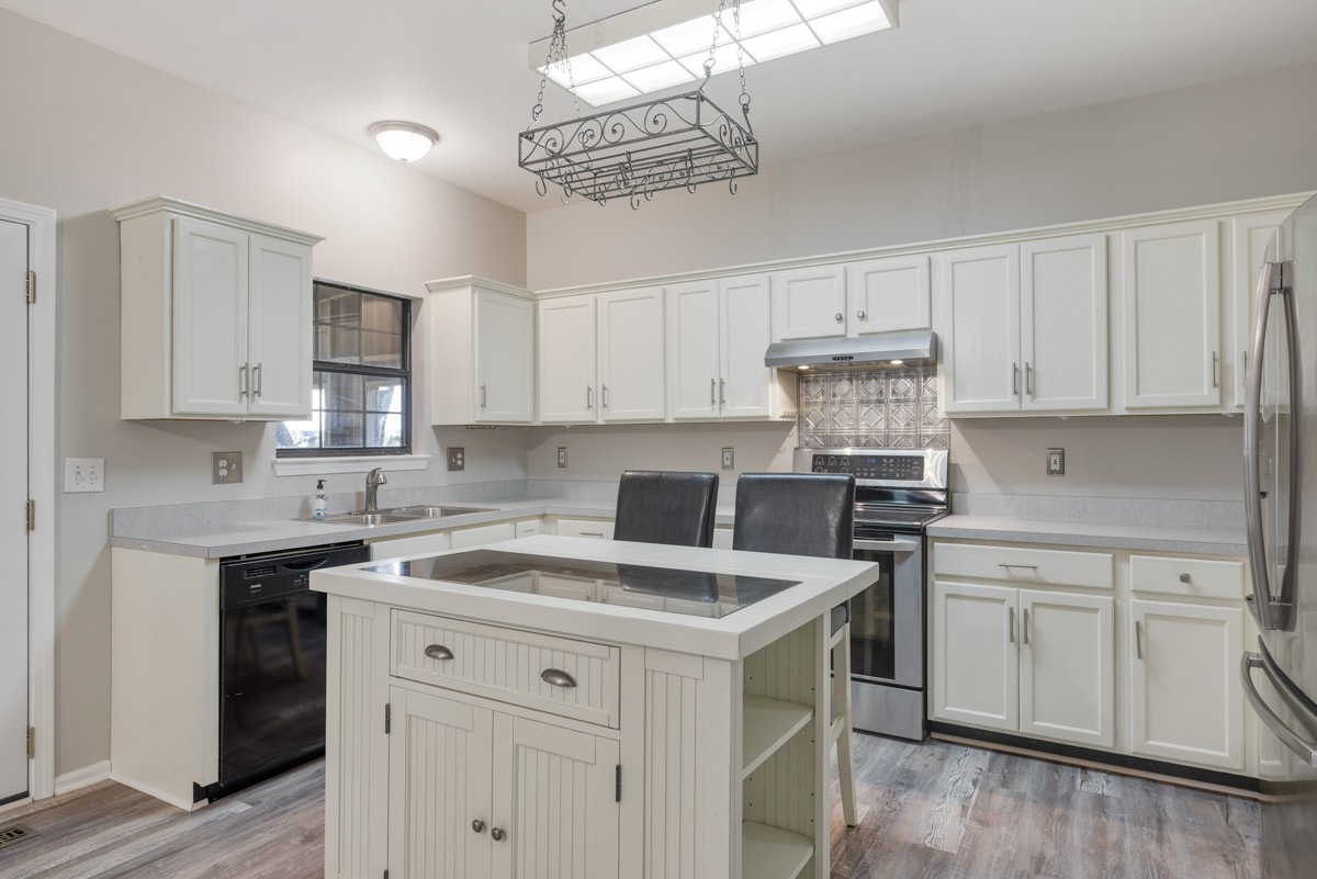 900 Dove Ridge Circle Nashville, TN 37221 - Photo 1 of 24 a kitchen with a sink dishwasher and white cabinets with wooden floor