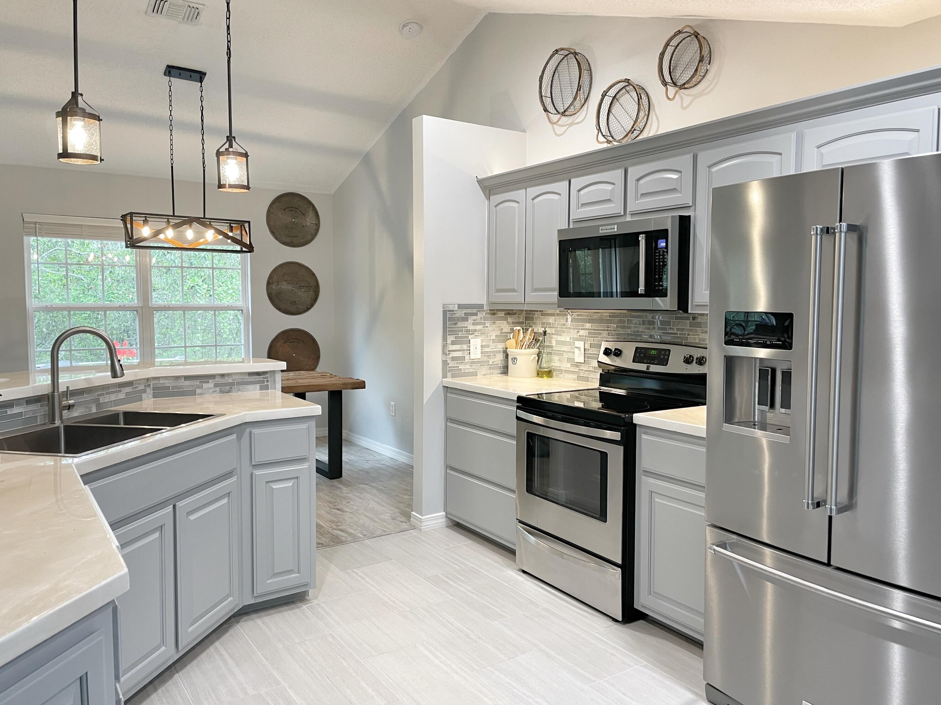 714 Riva Ridge Drive Crestview, FL 32539 - Photo 6 of 37 a kitchen with stainless steel appliances granite countertop a sink a stove a refrigerator and island with wooden floor
