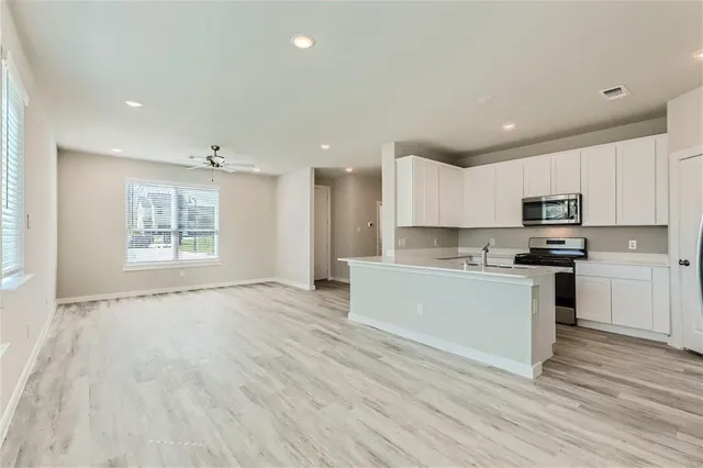 a kitchen with a refrigerator and white cabinets