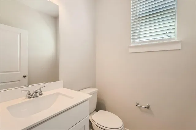a bathroom with a sink a toilet and mirror