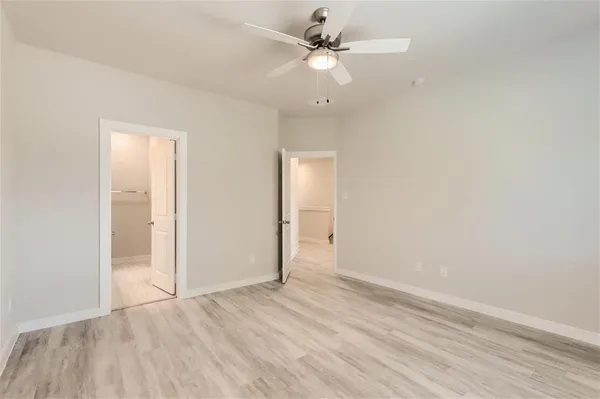 an empty room with a window and a ceiling fan