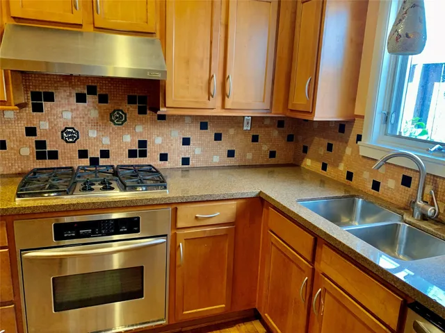 a kitchen with stainless steel appliances granite countertop a sink and a stove