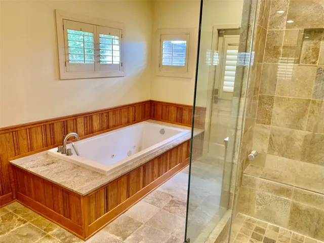 a bathroom with a tub a sink and a shower
