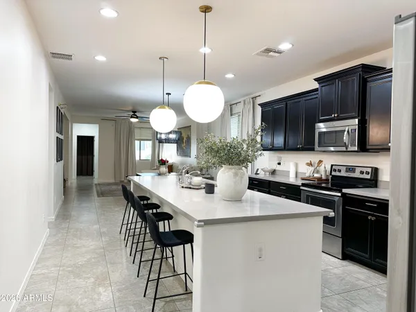 a kitchen with stainless steel appliances granite countertop a stove a sink dishwasher a microwave oven with cabinets and wooden floor