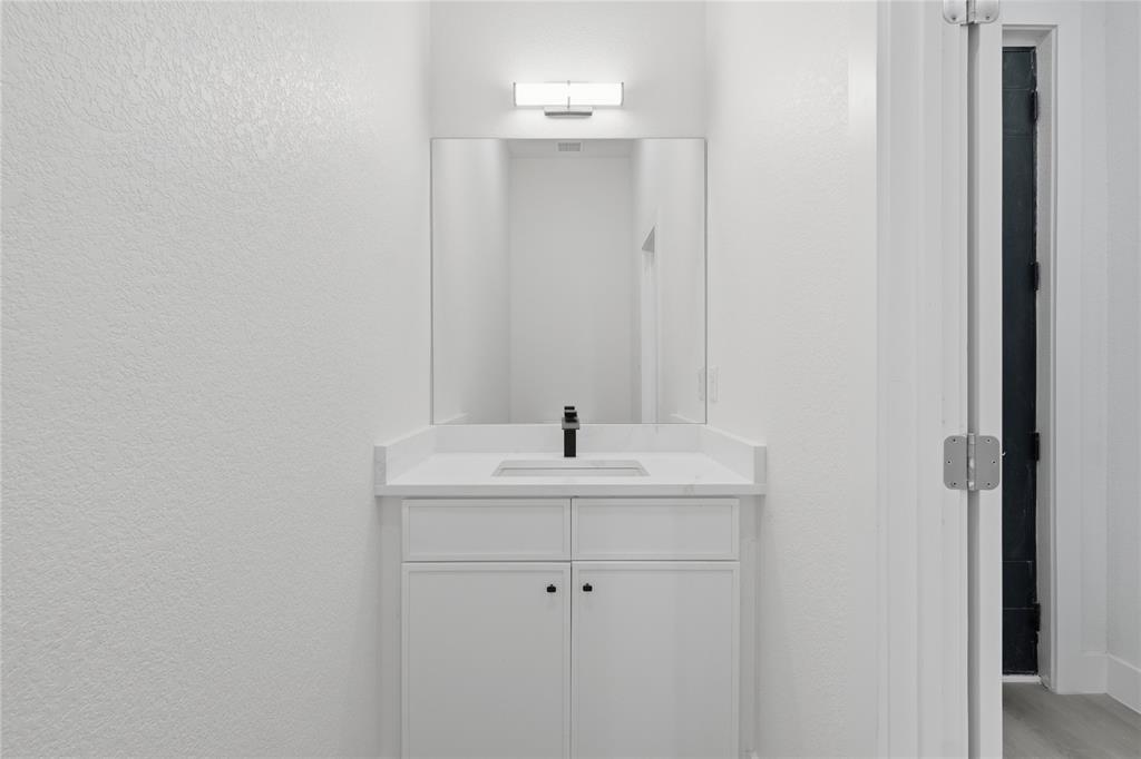 3905 Blue Ridge Boulevard Dallas, TX 75233 - Photo 3 of 25 White shaker-style vanity with a white countertop and integrated sink