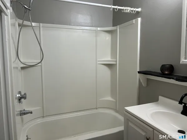 a bathroom with a granite countertop sink a toilet and shower