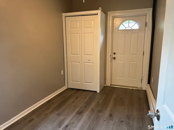 an empty room with wooden floor and mirror
