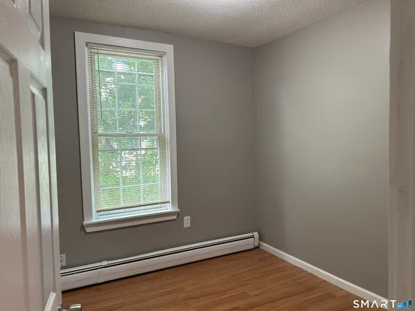 a view of a room with wooden floor and a window
