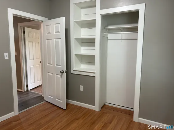 a view of an empty room with wooden floor