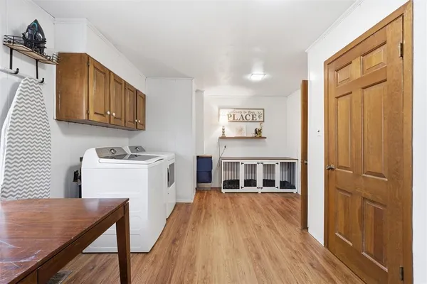 a view of a kitchen with a sink wooden floor and electronic appliances