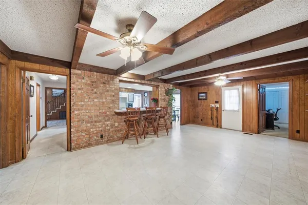 an empty room with chandelier fan and windows