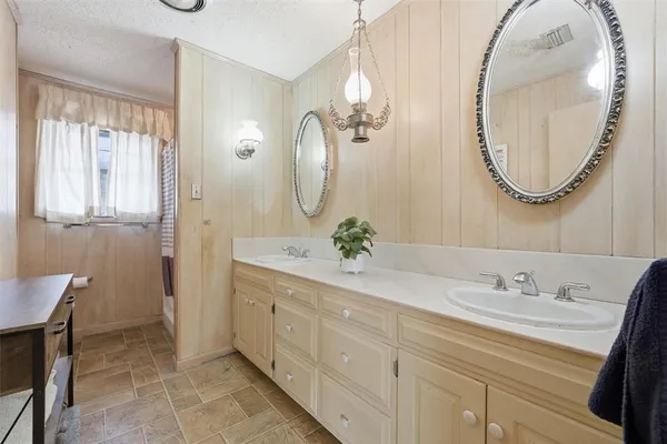 a bathroom with a double vanity sink and a mirror