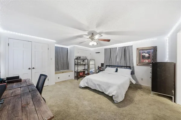 a spacious bedroom with a bed a desk and chair