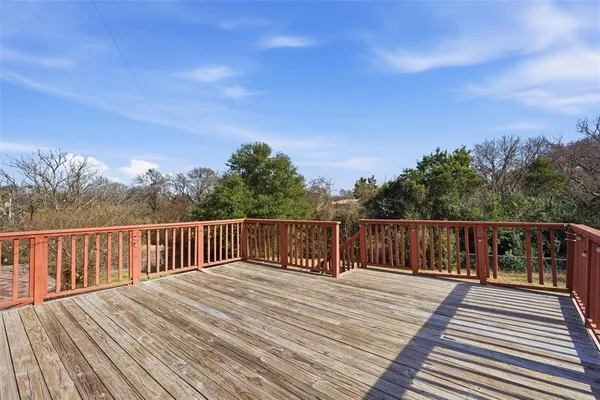 a view of deck with wooden floor and fence with a barbeque