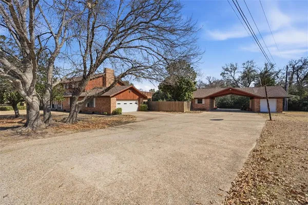 a front view of a house with a yard and trees