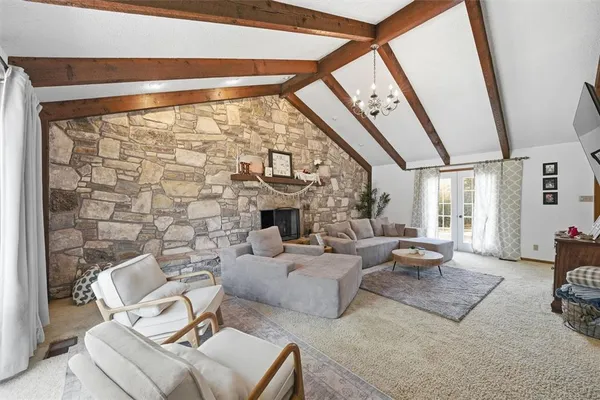 a living room with fireplace furniture and a large window