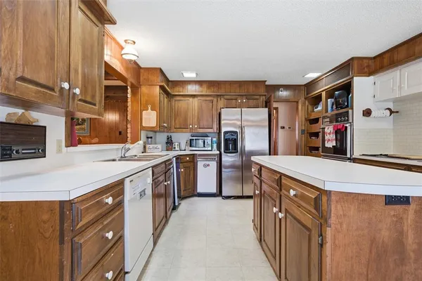 a kitchen with stainless steel appliances granite countertop a stove a sink and a refrigerator