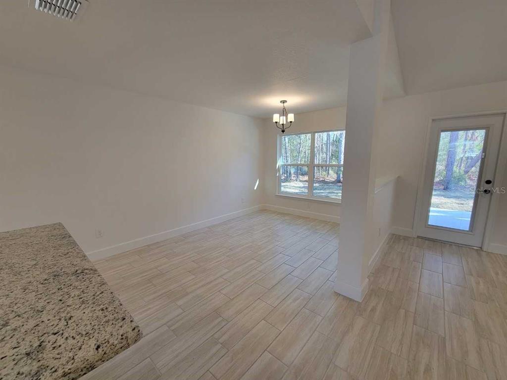 7035 Southwest 131st Loop Ocala, FL 34473 - Photo 12 of 28 wooden floor in an empty room with a window