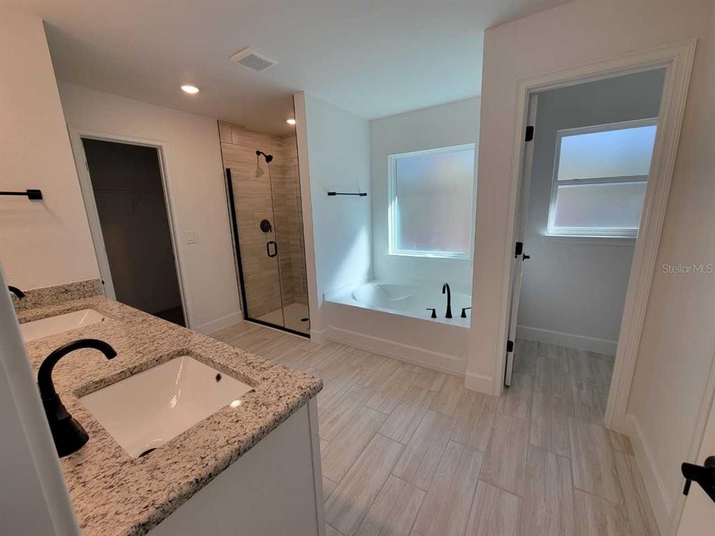 7035 Southwest 131st Loop Ocala, FL 34473 - Photo 19 of 28 a bathroom with a granite countertop sink a mirror and shower