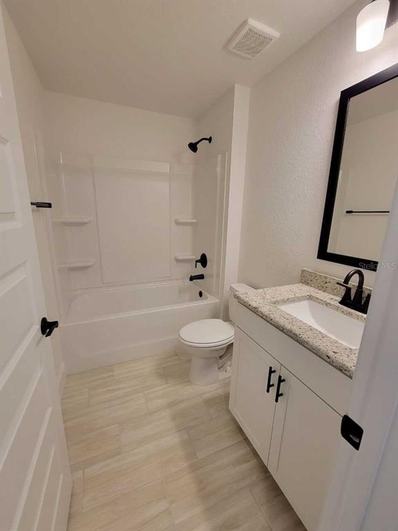 7035 Southwest 131st Loop Ocala, FL 34473 - Photo 24 of 28 a bathroom with a granite countertop sink a toilet a mirror and shower