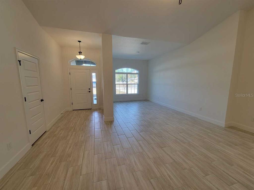 7035 Southwest 131st Loop Ocala, FL 34473 - Photo 3 of 28 wooden floor in an empty room with a window