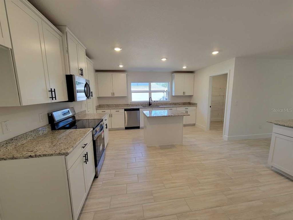 7035 Southwest 131st Loop Ocala, FL 34473 - Photo 6 of 28 a large kitchen with stainless steel appliances granite countertop a large counter top a stove a sink and a refrigerator