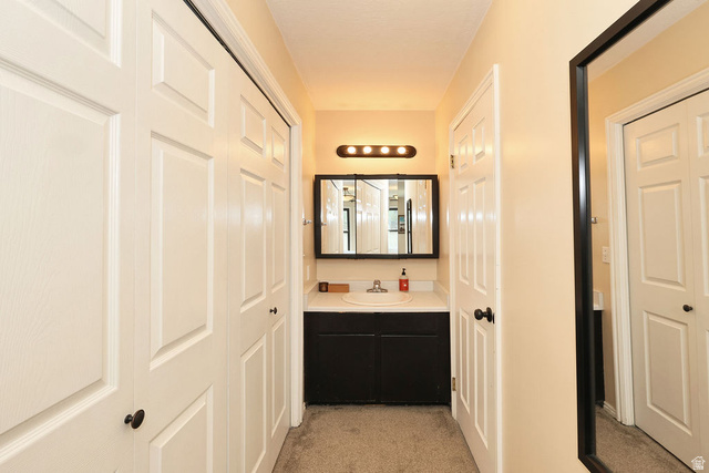 3104 East High Danish Road Sandy, UT 84093 - Photo 22 of 36 upstiars primary Vanity area featuring a built-in sink, dark wood-finish cabinetry, and a framed mirror