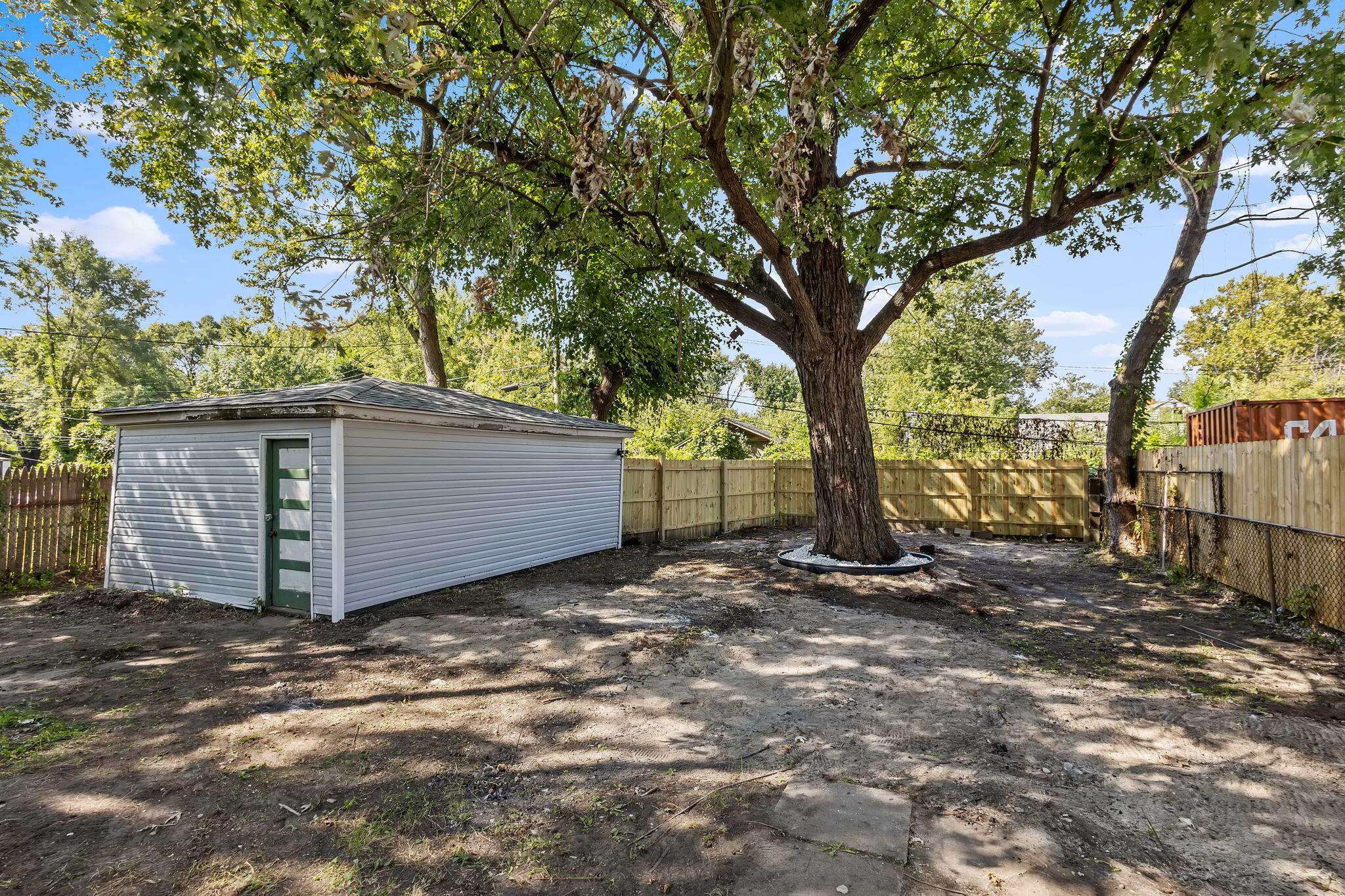 2368 Wheeler Street Gary, IN 46406 - Photo 14 of 16 a view of a house with large trees and wooden fence