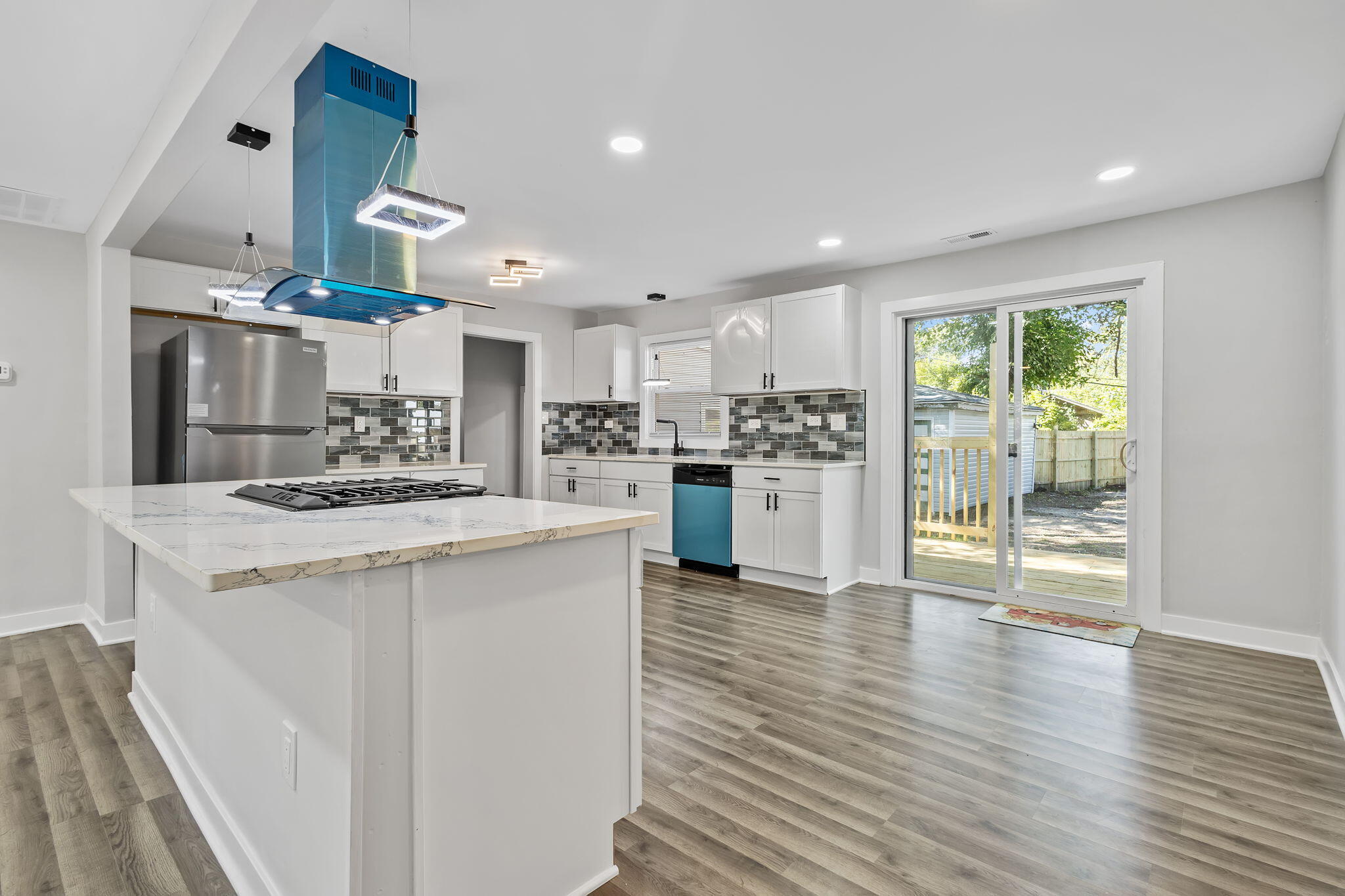 2368 Wheeler Street Gary, IN 46406 - Photo 5 of 16 a kitchen with stainless steel appliances kitchen island wooden floors and white cabinets
